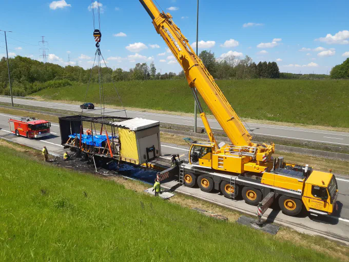 Grue mobile relevant une remorque accidentée sur autoroute