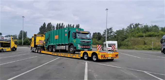 Camion-poubelle chargé sur la semi-remorque surbaissée