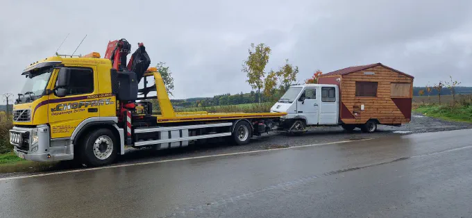 La Volvo FM remorque une camionnette et son chalet en bois
