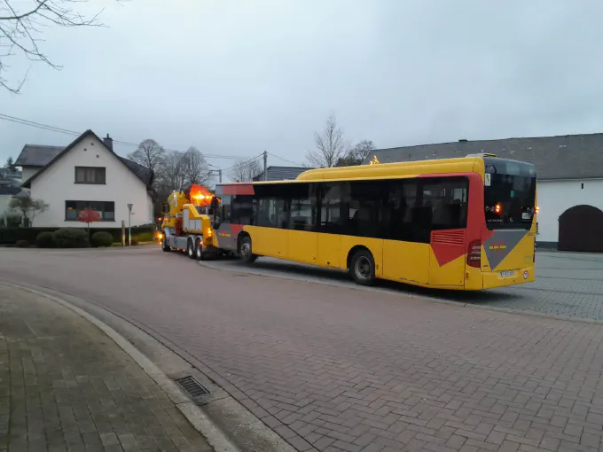 Bus de ligne remorqué au petit matin dans un village