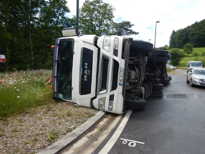 Camion MAN couché sur le flanc dans un rond-point