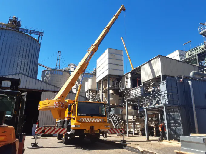 Grues à l'œuvre entre les silos d'un site industriel