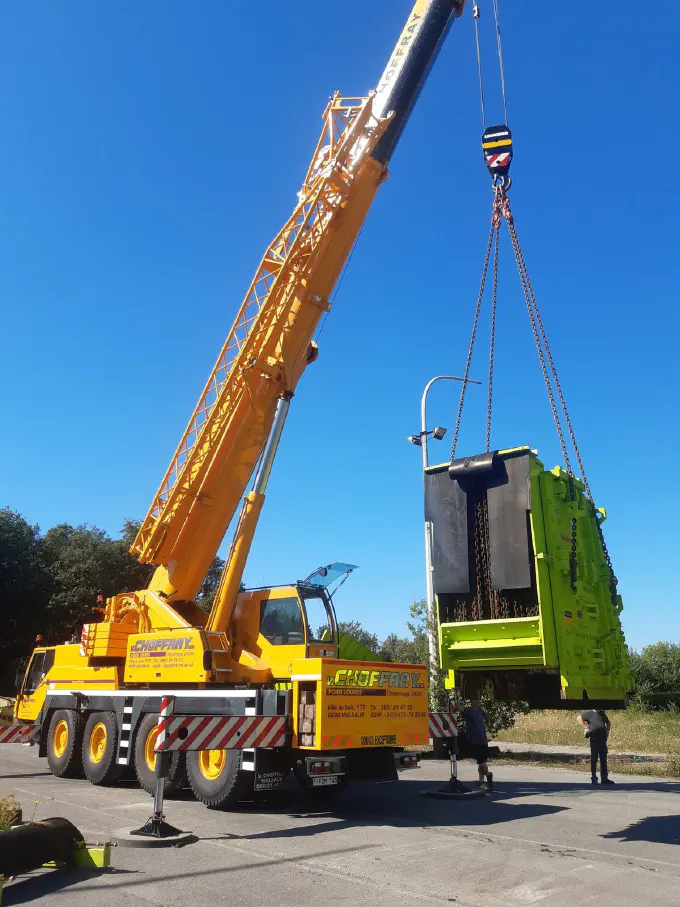 Levage d'une pièce de machine à la grue télescopique