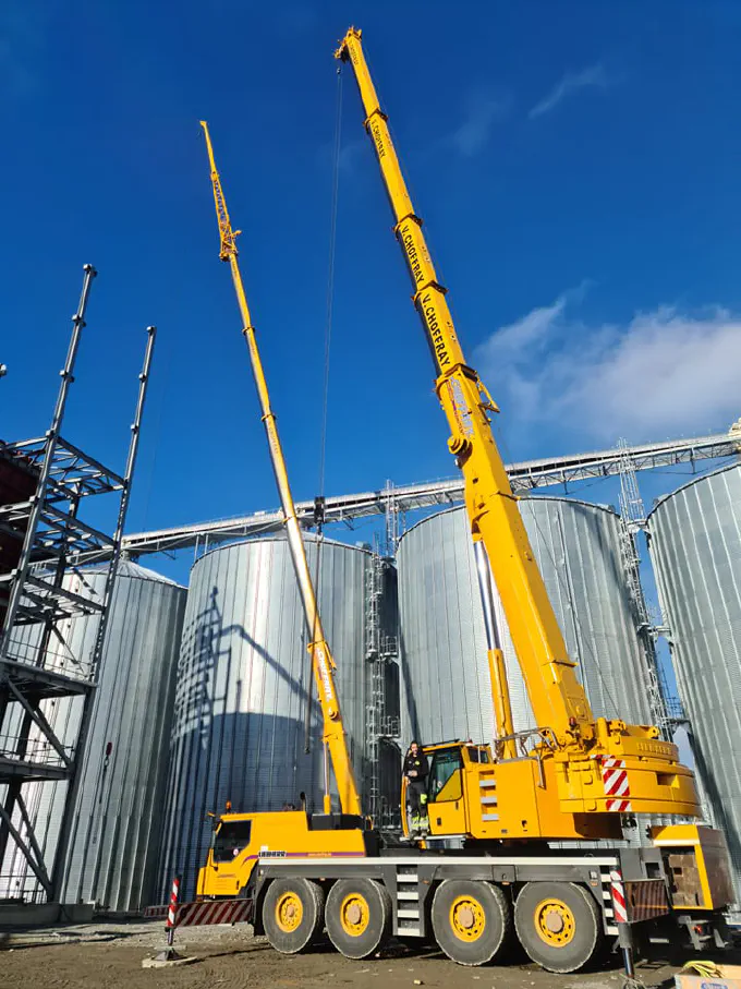Deux grues télescopiques dressées entre les silos