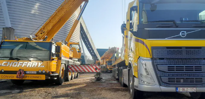 Grue et semi-remorque côte à côte sur chantier