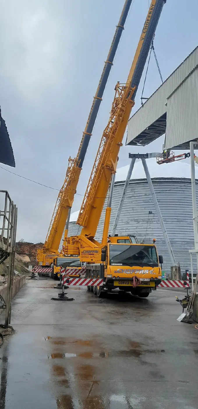 Deux grues hissent une structure sur le silo dôme