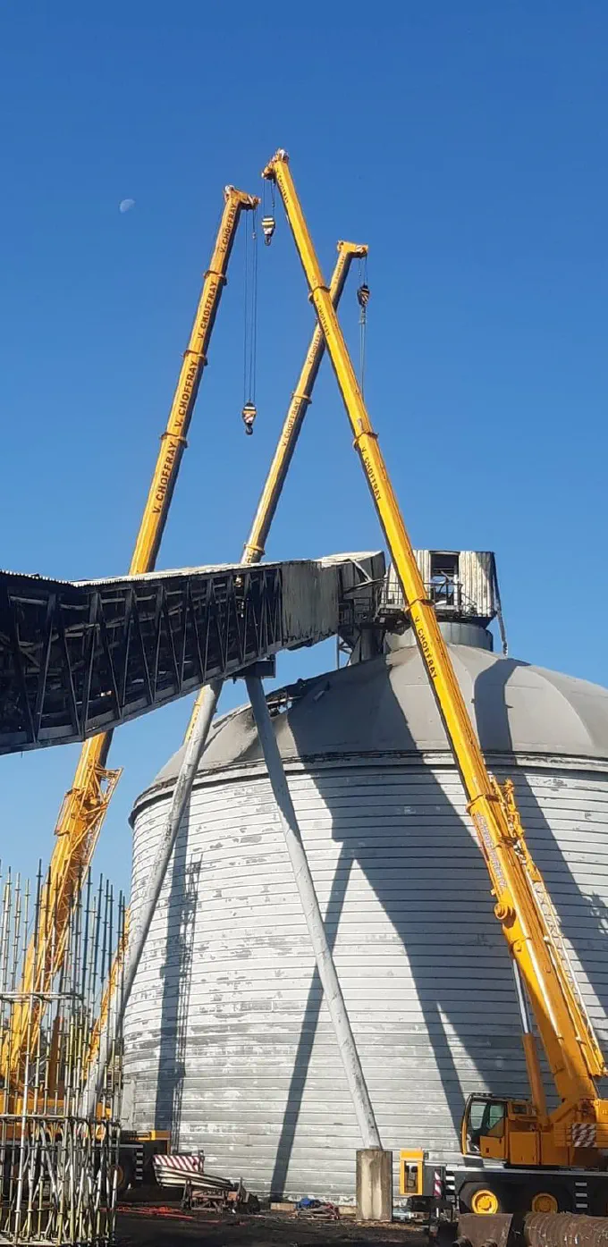 Grues télescopiques démontant un convoyeur de silo