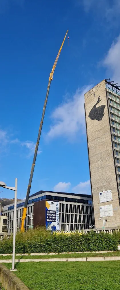Flèche télescopique déployée le long d'une tour en ville