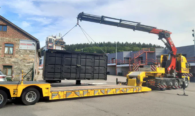 Grue HIAB chargeant un conteneur sur semi surbaissée